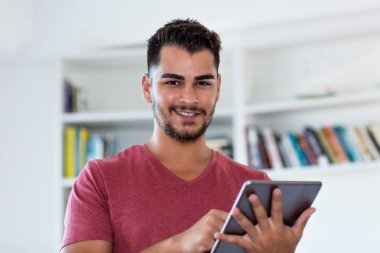 Çevrimiçi dijital tabletle gülen İspanyol hipster.