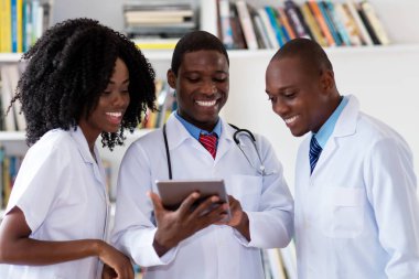 Afro-Amerikan doktorlardan oluşan bir ekip hasta hakkında konuşuyor.
