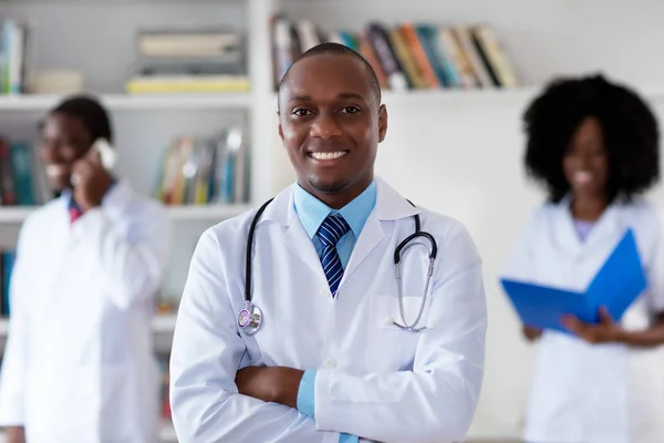 Médecin mûr afro-américain avec équipe médicale — Photo