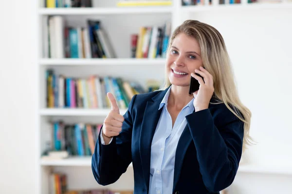 Başarılı sarışın iş kadını müşteriyle telefonda konuşuyor. — Stok fotoğraf