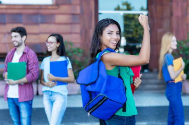 Başarılı bir Meksikalı kız öğrenci ve bir grup genç yetişkin.