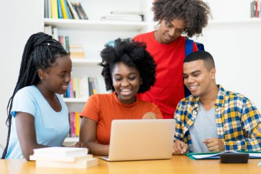 Bir grup Afrikalı Amerikalı ve Latin öğrenci üniversitenin bilgisayar sınıfında çalışıyor ve öğreniyor.