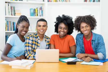 Afrikalı Amerikalı ve Latin öğrencilerin üniversitenin bilgisayar sınıfındaki grup fotoğrafı.