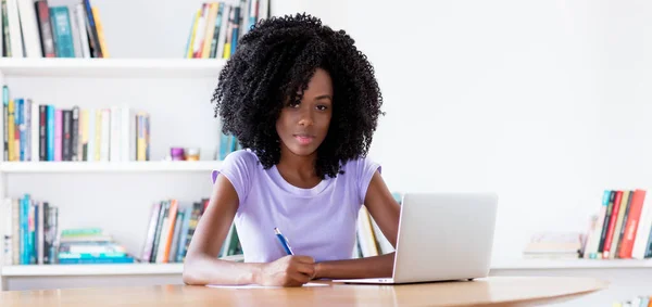 African american woman working at desk in quarantine indoors at home