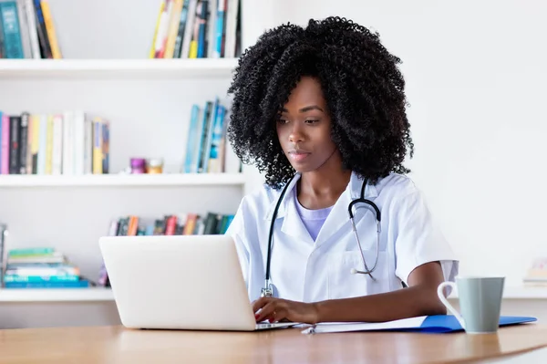 Researching african american medical female student at computer at hospital