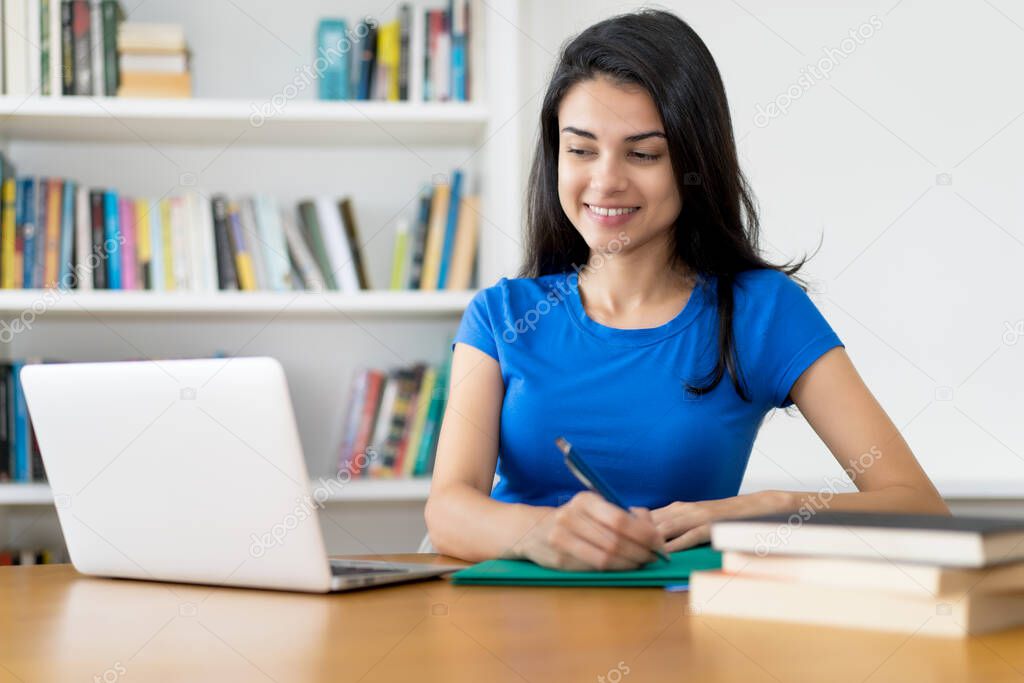 Learning turkish female student at desk at home or at library