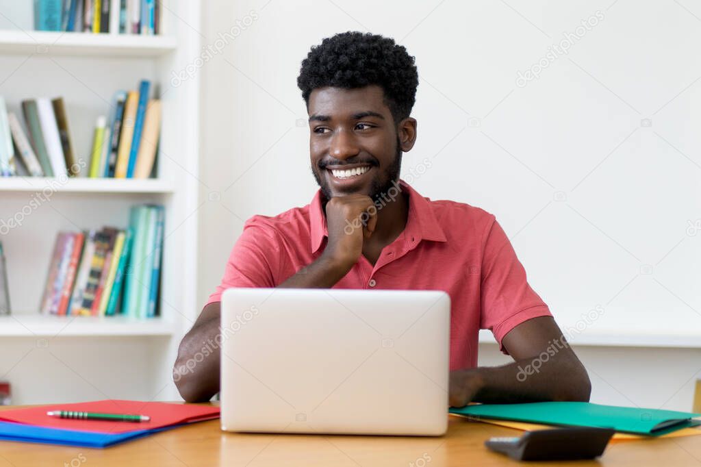 Smart afro american male student at computer indoors at home