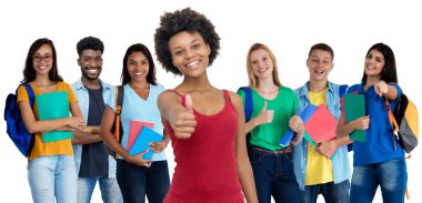 Oldukça Afrikalı Amerikalı genç yetişkin bir kadın geniş bir grup uluslararası öğrenciyle beyaz arka planda izole edilmiş.