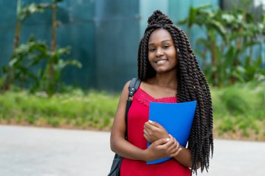 Yazın harika saç stili olan Afrikalı Amerikalı bir kız öğrenci. 