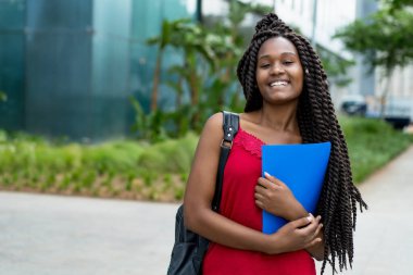 Yazın harika saç stili olan güzel Afro-Amerikan bayan öğrenci. 