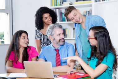 Üniversite sınıfındaki bilgisayar bilimleri öğrencilerine yazılımın programlanmasını ve kodlanmasını açıklayan öğretmen