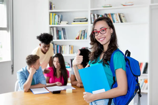 大学の教室で眼鏡をかけ外国人留学生のグループと幸せなオタク女子学生 — ストック写真