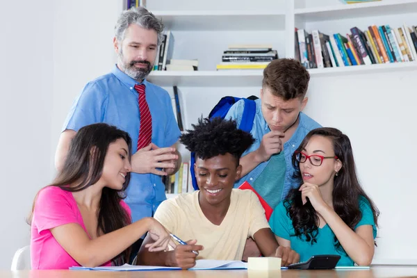 Teacher with group of multi ethnic international students at classroom of university