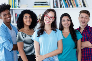 Bir grup Latin ve Afrikalı Amerikalı ve Latin kökenli genç kadın ve İspanyol erkek üniversite sınıfında.