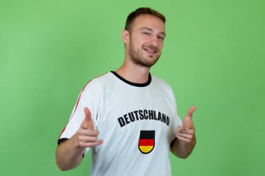 Almanya 'dan yakışıklı futbol taraftarı yeşil arka planda izole edilmiş 