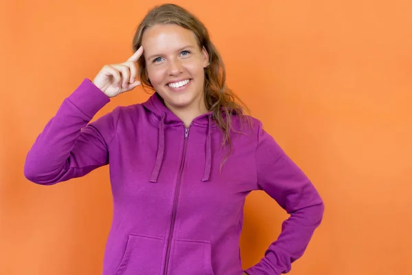 Smart Blond German Young Adult Woman Hoody Isolated Orange Background — Stock Photo, Image