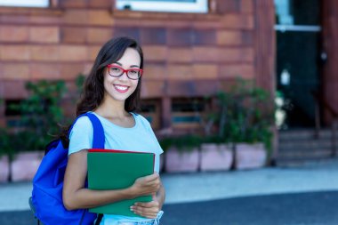 Uzun siyah saçlı, güzel bir kız öğrenci. Şehirde gözlüklü.