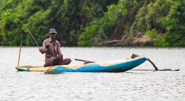 Râul Sri Lanka, turismul srilankan, Pescarul lacului în acțiune atunci când pescuiește pe amurg, cultura Srilankan și turism.barcă de lemn cu tijă de pescuit . — Fotografie, imagine de stoc