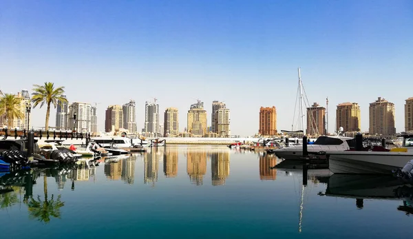 01 Július 2019; Pearl Katar, Porto Arábia, Pearl-Katar sziget Doha.Panoráma luxus lakóépületek Pearl Katar és fehér jachtok Porto Arábia kikötő. Doha, Katar. — Stock Fotó