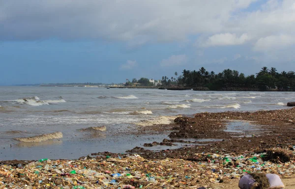 Sea Pollution: Garbage dumped in the Sri Lankan Sea near Colombo. women collects plastic things in a pile of garbage brought by the surf from the sea