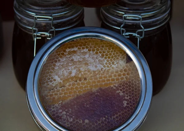 Honey and comb. Honey packed in glass bottles for sale. — Stock Photo, Image