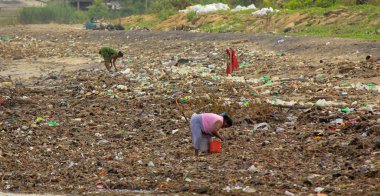 Deniz Kirliliği: Sri Lanka plajındaki dalgaların getirdiği çöp yığınında kadınlar plastik şeyler topluyor.
