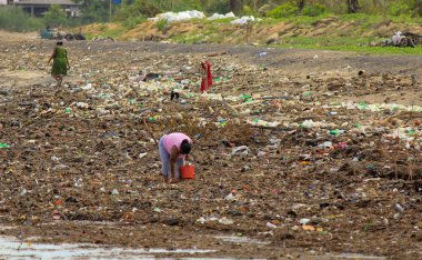 Deniz Kirliliği: Sri Lanka plajındaki dalgaların getirdiği çöp yığınında kadınlar plastik şeyler topluyor.