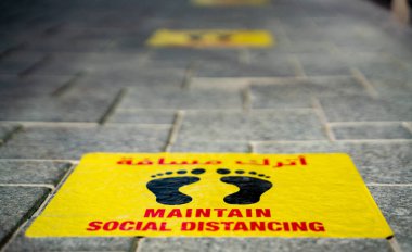 Katar Katar 'daki restoranın önüne yapıştırılmış sosyal mesafe etiketlerini koru