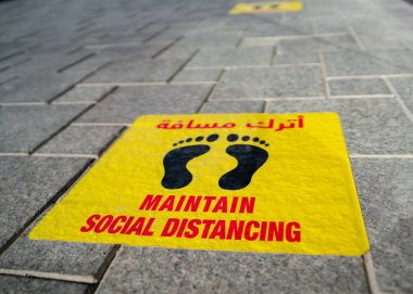 Katar Katar 'daki restoranın önüne yapıştırılmış sosyal mesafe etiketlerini koru