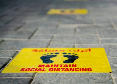 Katar Katar 'daki restoranın önüne yapıştırılmış sosyal mesafe etiketlerini koru