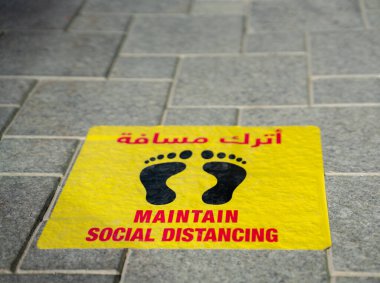 Katar Katar 'daki restoranın önüne yapıştırılmış sosyal mesafe etiketlerini koru