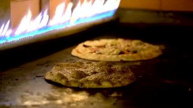 Bir restoranda gaz sobasının içinde pişmiş Arap pizzaları..