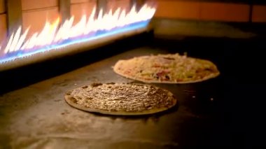 Bir restoranda gaz sobasının içinde pişmiş Arap pizzaları..