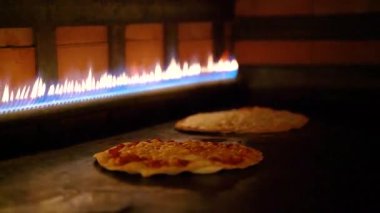 Bir restoranda gaz sobasının içinde pişmiş Arap pizzaları..