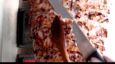 Shawarma kıvrımını keserken yakın çekim.