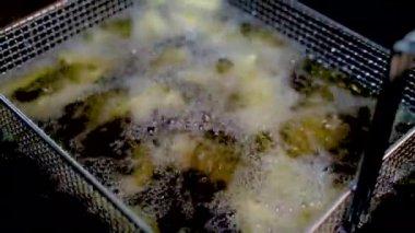French fries in the deep fryer, in a fast food restaurant. crispy potato fries