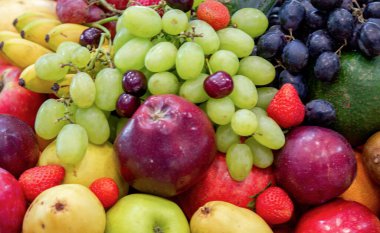 arkaplan: Satılık bir dükkanda çeşitli taze meyvelerin karışımı