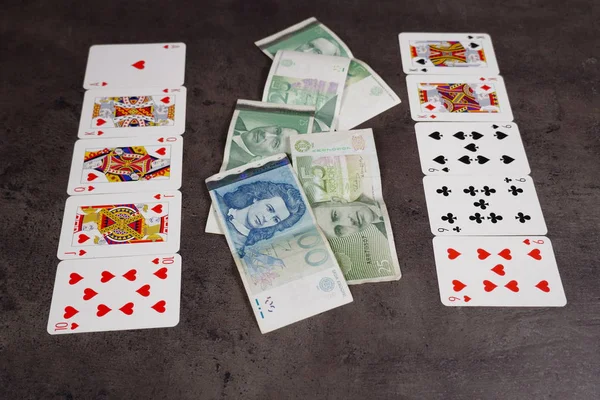Die Kombination von königlichen Blitzkarten auf einem grauen Tisch mit Geld und Gold. Nahaufnahme. Pokerspiel — Stockfoto