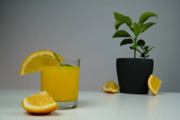 Стакан свежего апельсинового сока на белом столе — стоковое фото