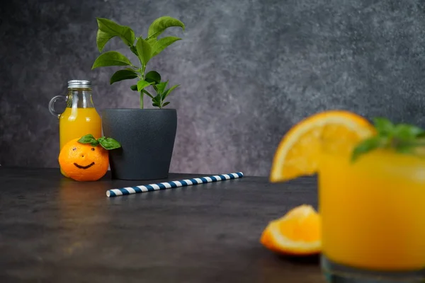 Un vaso de zumo de naranja fresco sobre fondo gris . — Foto de Stock