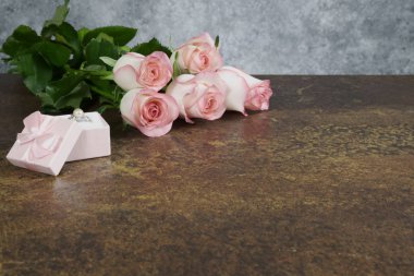 gri arka plan ile paslı masada güller