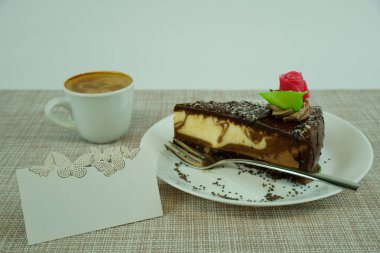 Beyaz arka planda coffe fincan ve isim kartı ile lezzetli çikolatalı kek Parçası