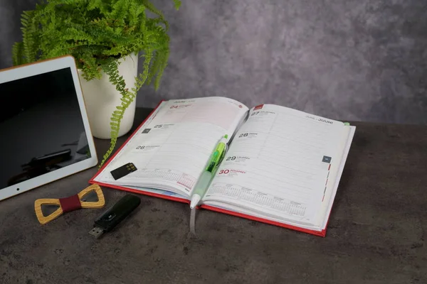 Vista superior Mesa de trabalho do escritório com bloco de notas e tablet e flor verde — Fotografia de Stock