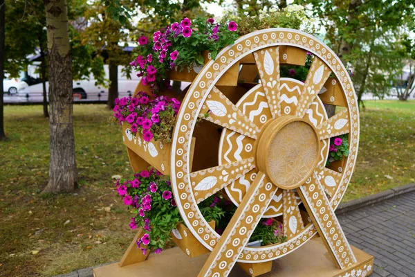 Flower bed made of wood in wheel shape. close up photo