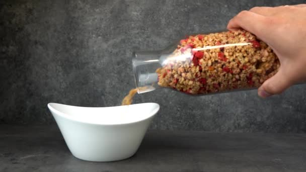 Muesli with srawberry and cranberry in white bowl on grey concrete table. — Stock Video