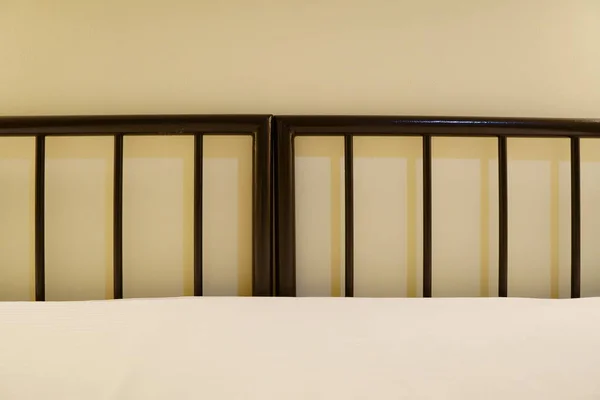 metal bed in a hotel room without pillows