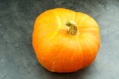 Güzel turuncu balkabağı, beton masaya yakın fotoğraf.
