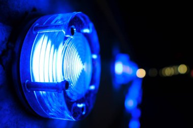 Yuvarlak mavi lamba, koyu arkaplanda. Yakın çekim.