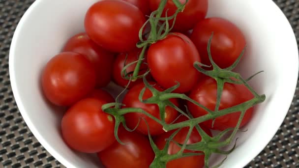 Obracające się pomidory wiśniowe w białej misce, 4k wideo — Wideo stockowe