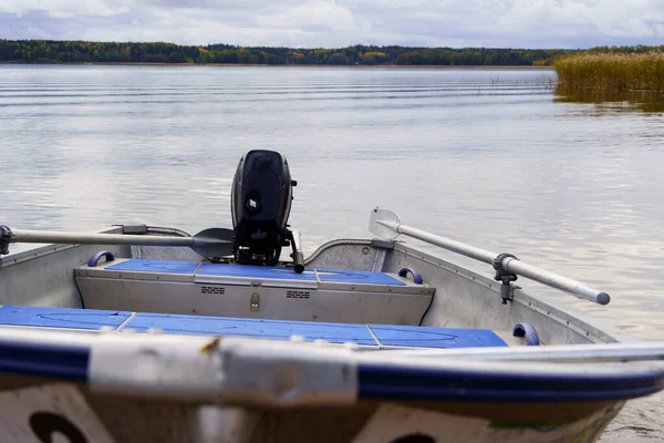 Aluminum fishing boat close up front view, in the background a blurred background of the sea and forest. — ストック写真